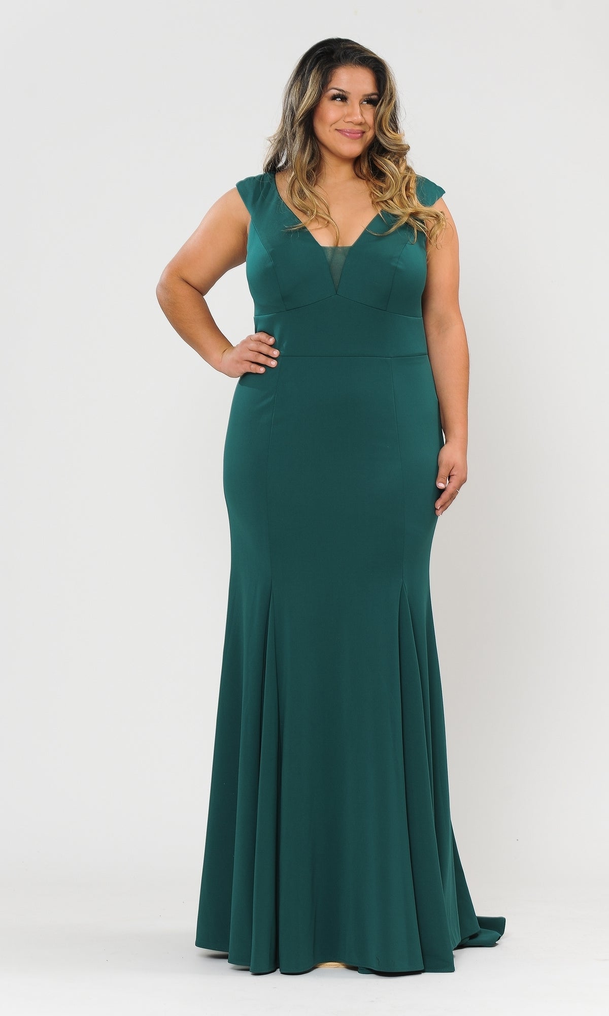 A woman stands against a plain white background wearing the Classic Sleeveless Plus-Size Long Prom Dress W1022 in deep green, featuring a floor-length design with a fitted bodice and flared skirt.